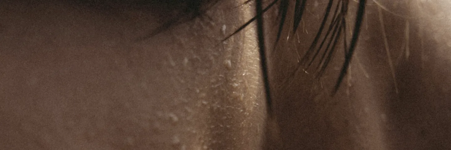 Water beading across a shoulder, caught in low light.