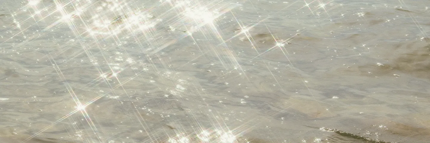 Sunlight breaking into repeating points across shallow water.