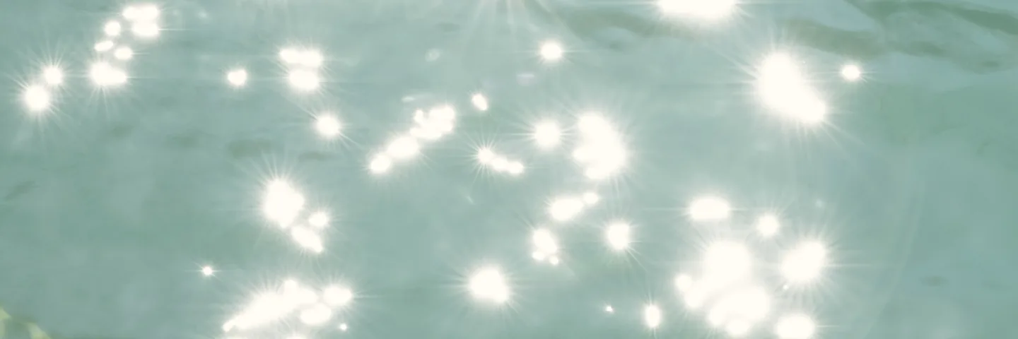 Sunlight breaking into points across clear green water.