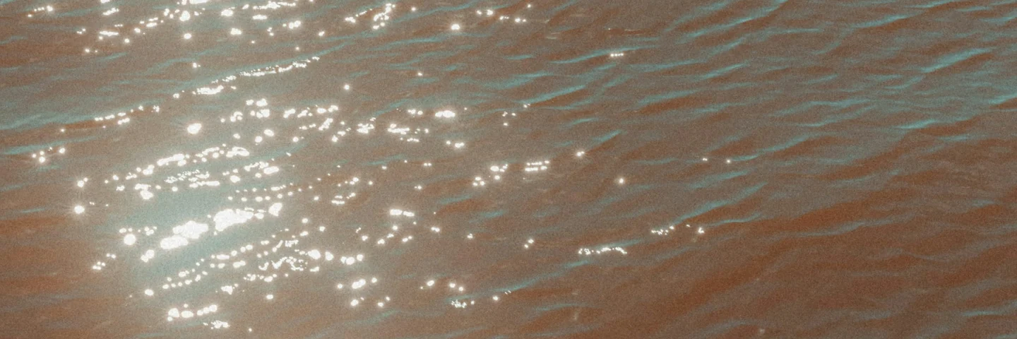 Sunlight breaking into points across shallow water.